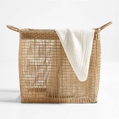 an empty basket with a white towel hanging from the top, and another item in front of it