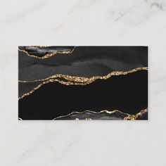 black and gold marble business card with glittery lines on the bottom, in front of a white background