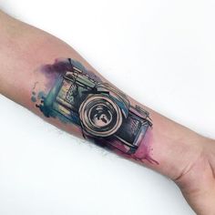 a camera tattoo on the left arm