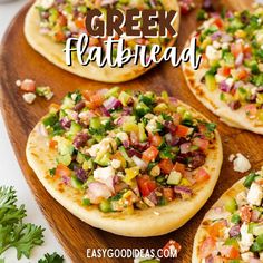 homemade greek flatbreads with fresh vegetables and feta cheese on a wooden platter