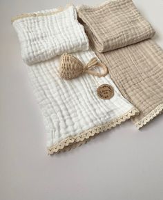 two white and beige bedspreads with lace trims on them are laying next to each other