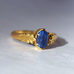 A beautiful Natural Ceylon Sapphire ring. The buttery yellow hand-made mounting tests to 22k in gold fineness. The cathedral-style mounting has a tapered style shank measuring 3.3 mm in width tapering to 2.4 mm at the base of the shank. Prong set into the ring is an oval-shaped and faceted natural blue sapphire measuring 7.47 x 5.00 mm. The sapphire has medium Ceylon blue body color and is of A quality. Both sides of the ring have fleur-de-lis style design work. The ring mounting weighs 3.2 dwt with stone. The setting is closed back. This piece exhibits usual wear associated with age, please see the detailed photos included with this listing for a full account of the condition.  This item is sold as-is, no returns.  Please ask any questions prior to purchase.  Thank you for looking!   US s Heirloom Yellow Sapphire Gold Ring, 22k Yellow Gold Ring With Bezel Setting, Formal Gold Ring With Yellow Sapphire, Yellow Gold 22k Bezel Set Ring, Formal Gold Sapphire Ring With Yellow Sapphire, Gold Hand Forged Sapphire Ring, Hand Forged Gold Sapphire Ring, Gold Sapphire Rings Hand Forged, Gold Oval Yellow Sapphire Ring