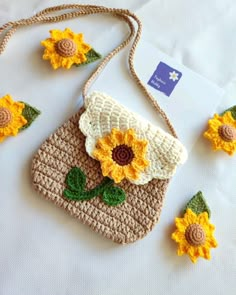 a crocheted purse with sunflowers on the front and two small flowers on the back