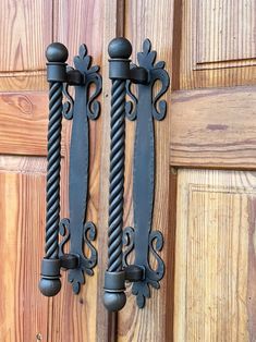 two black iron handles on a wooden door