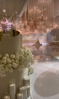 a fancy bathroom with chandeliers and flowers in the bathtub, surrounded by candles