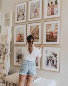 a woman standing in front of pictures on the wall