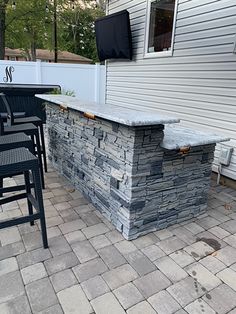 an outdoor bar with four chairs around it