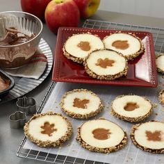 cookies with peanut butter on them sitting on a cooling rack next to an apple and other desserts