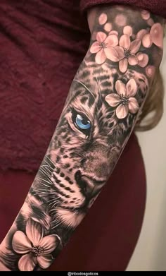 a woman's arm with a tiger and flowers on it