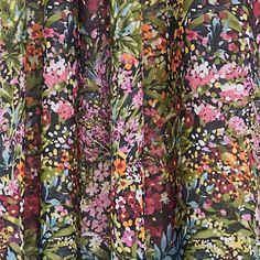 a close up view of a floral print dress with long sleeves and pleaed hems