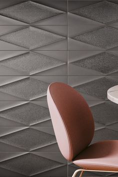 a chair and table in front of a wall with geometric tiles on it's sides