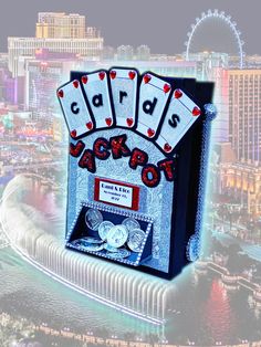 the las vegas card game is displayed in front of an image of casino buildings and ferris wheel