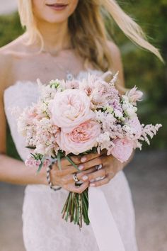 a woman holding a bouquet of flowers in her hands