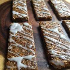 some kind of food that is sitting on a wooden tray with white icing and drizzled