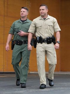 two men in uniform walking down the street