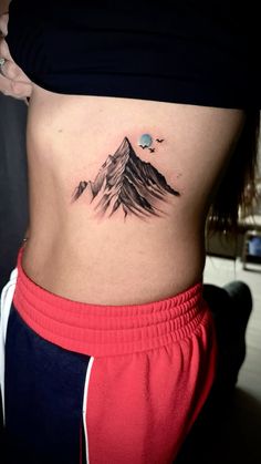 a woman with a mountain tattoo on her stomach