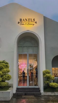 the front entrance to ranels cafe and bakery on a rainy day with people standing outside