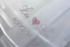 two hearts are embroidered onto the white fabric with silver sequins on it, which says love