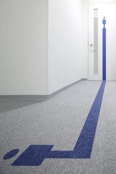 an empty room with a blue arrow painted on the floor and a door in the background