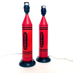 two red crayon style lamps are sitting next to each other