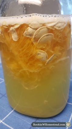 a glass jar filled with liquid sitting on top of a blue tablecloth covered table