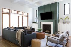 a living room filled with furniture and a flat screen tv mounted on the wall above a fireplace