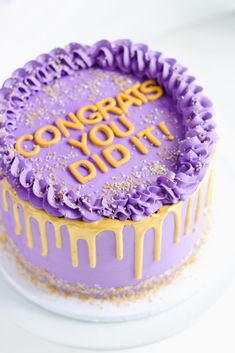 a purple cake with yellow icing that says congrats yogurt on it