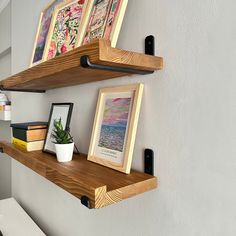 two wooden shelves with pictures and books on them