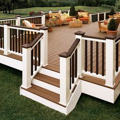 a wooden deck with white railings and brown steps