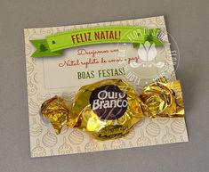 a chocolate candy bar wrapped in foil on top of a piece of paper with a green ribbon