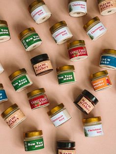 many jars of different types of food are arranged on a pink surface with the words happy new year written in them