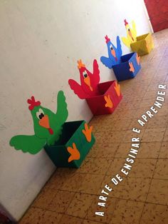 colorful paper birds are lined up on the floor in front of a wall with words