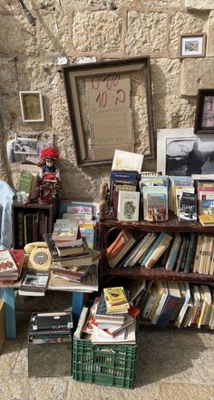 there are many books on the table and in front of this book stand that is full of books