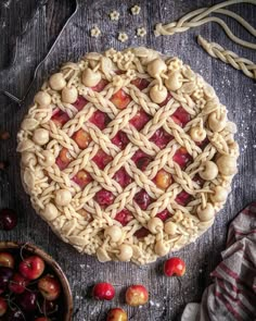 an apple pie with latticed crust and cherries around it