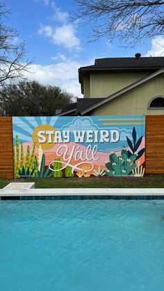 a pool with a mural on the side of it that says stay weird you're