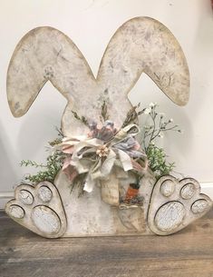 a wooden sign with an animal's paw and flowers on it