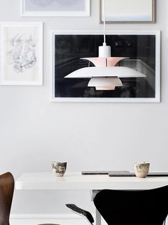 a white table with chairs and pictures on the wall