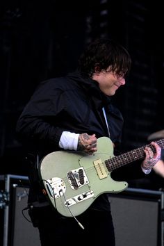 a young man playing an electric guitar on stage