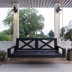 a wooden porch swing sitting on top of a white floor next to potted plants