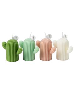 three cactus shaped candles in different colors