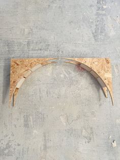 a curved piece of wood sitting on top of a cement floor