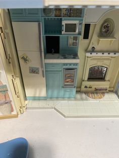 a doll house kitchen with blue cabinets and appliances