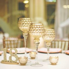 the table is set with gold glasses and place settings