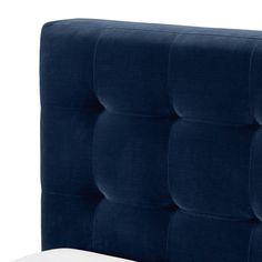 an upholstered headboard with buttons on the top and bottom, in dark blue velvet