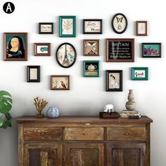 there are many framed pictures on the wall above an old wooden cabinet and sideboard