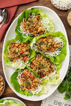 lettuce wraps filled with meat and veggies on top of a white plate