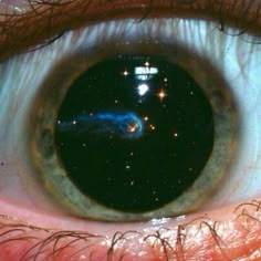 an eye looking at the sky with stars in it's iris and blue eyes