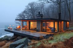 a house on the edge of a cliff with candles lit up in front of it