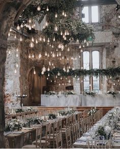 the tables are set up with white flowers and greenery for an elegant wedding reception