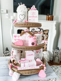 a three tiered cake decorated with pink and white decorations on top of a table